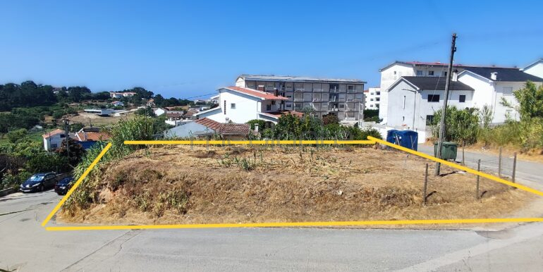 Ambiente residencial consolidado. Imagem com terreno cercado e casas ao fundo
